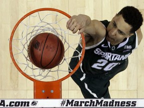 Michigan State's Travis Trice dunks against Virginia during the Round of 32 in Charlotte, N.C. (AP Photo/Gerald Herbert)