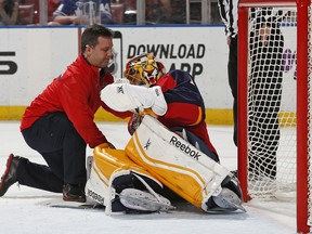 Florida goaltender Roberto Luongo, right, is checked by a team trainer after being injured during the first period against the Toronto Maple Leafs in Sunrise, Fla. (Photo by Joel Auerbach/Getty Images)