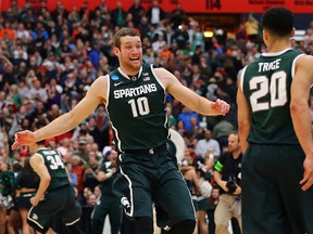 Matt Costello #10 and Travis Trice #20 of the Michigan State Spartans celebrate defeating the Louisville Cardinals 76 to 70 in overtime of the East Regional Final of the 2015 NCAA Men's Basketball Tournament at Carrier Dome on March 29, 2015 in Syracuse, New York.  (Photo by Elsa/Getty Images)