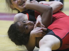 L'Essor's Virginia Gascon, below, battles Nicole Mayer of St. Jean De Brebeuf during OFSAA wrestling championship at the WFCU Centre in Windsor, ON. on Tuesday, March 3, 2015. (DAN JANISSE/ The Windsor Star)