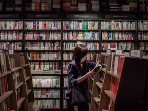 In this file photo, a woman checks a book in a bookstore. AFP PHOTO / Philippe Lopez/AFP/Getty Images