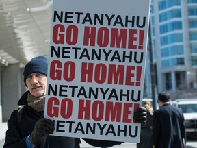 A man holds a sign outside the Washington Convention Center where Israeli Prime Minister Benjamin Netanyahu addressed the American Israel Public Affairs Committee (AIPAC) policy conference inb Washington, DC, on March 2, 2015. Netanyahu is ramping up his mission to foil an emerging White House-backed nuclear deal with Iran with the speech to the powerful pro-Israel AIPAC lobby.   AFP PHOTO/NICHOLAS KAMMNICHOLAS KAMM/AFP/Getty Images