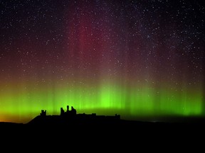 The aurora borealis, or the northern lights as they are commonly known are photographed, over Dunstanburgh Castle, in Northumberland, England, Tuesday Feb. 17, 2015. (AP Photo/PA, Owen Humphreys)