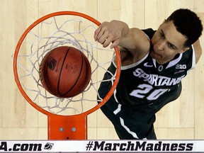 Michigan State's Travis Trice (20) dunks against Virginia during the first half of the NCAA tournament in the Round of 32 in Charlotte, N.C., Sunday, March 22, 2015. Michigan State won 60-54. (AP Photo/Gerald Herbert)