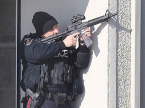 A heavily armed Windsor police officer is shown on Campbell Avenue in Windsor, Ont. on Monday, March 2, 2015 where a man was arrested. (DAN JANISSE/ The Windsor Star)