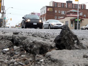 Crumbling asphalt and a pothole are on display at Wyandotte and Pelissier Street in downtown Windsor on Mar. 23, 2015. (Jason Kryk / The Windsor Star)