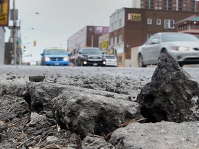 Crumbling asphalt and a pothole are on display at Wyandotte and Pelissier Street in downtown Windsor on Mar. 23, 2015. (Jason Kryk / The Windsor Star)