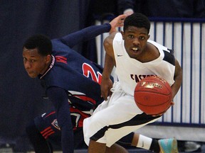 Holy Names High School's Alston Gayle loses the ball to Eastern Commerce's Khosheem Simpson during OFSAA basketball action at the St. Denis Centre in Windsor on Monday, March 9, 2015. (TYLER BROWNBRIDGE/The Windsor Star)