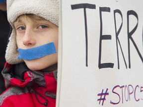 A young boy demonstrates to protest on a national day of action against Bill C-51, the government's proposed anti-terrorism legislation, in Montreal, Saturday, March 14, 2015. THE CANADIAN PRESS/Graham Hughes