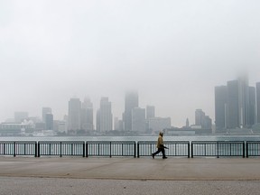 Anthony Ennis walks along the foggy downtown Windsor waterfront, Thursday, March 26, 2015. (Gabrielle Smith/The Windsor Star)