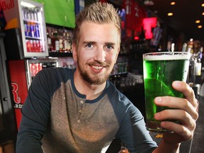Ryan McAiney displays a pint of green beer on Monday, March 16, 2015, at the Manchester Pub in Windsor. After being closed for a few weeks due to a flooding incident, the downtown bar is ready to celebrate St. Patrick's Day. (DAN JANISSE/ The Windsor Star)