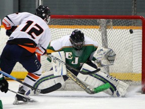 L'Essor's J.F. Brule, left.  fires the puck at Lajeunesse's Dershaha Stewart at Tecumseh Arena Thursday. (TYLER BROWNBRIDGE/The Windsor Star)