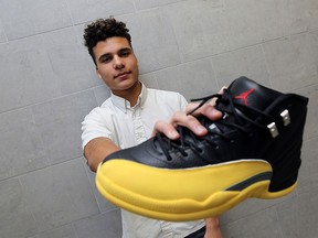 Zaheem Riberdy holds up a shoe he is working on at Assumption High School in Windsor on Tuesday, March 31, 2015. Riberdy has started a business customizing shoes and is entered in a contest run by the Ontario Ministry of Economic Development.             (TYLER BROWNBRIDGE/The Windsor Star)