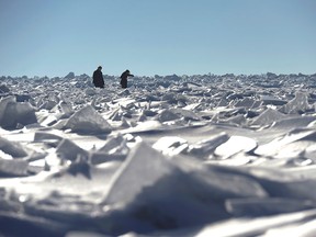 Two women navigate their way among mounds of frozen ice on Lake Michigan in South Haven, Mich., Sunday, March 8, 2015. (AP Photo/The Herald-Palladium, Don Campbell)