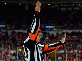 Referee Evgeny Romasko calls a penalty in the second period during a game between the Detroit Red and the Edmonton Oilers in Detroit Monday, March 9, 2015. Romasko is the first Russian referee in NHL history. (AP Photo/Paul Sancya)
