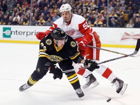 Boston Bruins' Brad Marchand (63) tries to get a shot off as Detroit Red Wings' Jonathan Ericsson (52) defends during the second period of an NHL hockey game in Boston, Sunday, March 8, 2015. (AP Photo/Michael Dwyer)