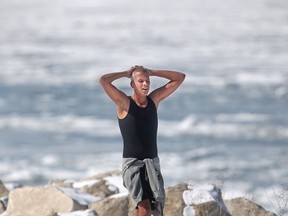 A man takes a break from running in shorts and a tank top on Windsor's riverfront on March 2, 2015. (Dax Melmer / The Windsor Star)