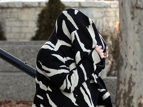 Sabrina Lacommare hides her face as she leaves Superior Court in Windsor in this January 2015 file photo. (Nick Brancaccio / The Windsor Star)