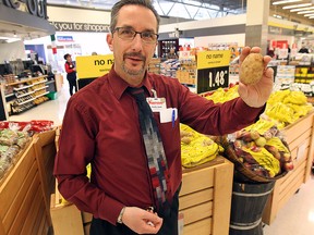 Curtis Scott, assistant store manager at the Real Canadian Superstore on Dougall Ave. in Windsor, ON. displays a potatoe from the Naturally Imperfect line. The line is up to 30 per cent less expensive than traditional produce options found at the store. (DAN JANISSE/ The Windsor Star)