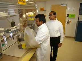 University of Windsor professor Jerald Lalman, right, watches as post doctoral fellow Subbarao Chaganti prepares sugar solutions that will be converted into hydrogen. (Windsor Star files)