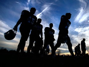 Football players are silhouetted against a brilliant summer sky as they leave the field in this file photo. (JASON KRYK/The Windsor Star)