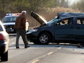 A coroner makes observations at the scene of a double fatal rollover involving a Honda Odyssey minivan on Highway 3 west of Morse Road where OPP are investigating Wednesday, April 29, 2015. (NICK BRANCACCIO/The Windsor Star)