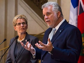Quebec Premier Philippe Couillard, right, and Ontario Premier Kathleen Wynne, are pictured on August 21, 2014 in Quebec City. THE CANADIAN PRESS/Clement Allard