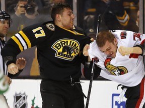 Boston Bruins' Milan Lucic (17) fights with Ottawa Senators' Mark Borowiecki during the second period of an NHL hockey game in Boston Saturday, Dec. 13, 2014. (AP Photo/Winslow Townson)