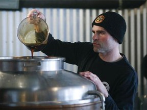 In this Friday, March 20, 2015 photo, brewer Matthew Perry adds maple syrup to a tank while making maple amber beer at Chatham Brewing in Chatham, N.Y. (AP Photo/Mike Groll)