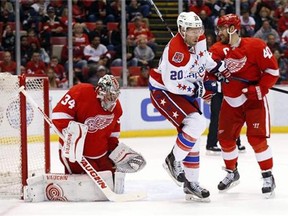Detroit Red Wings goalie Petr Mrazek (34) stops a shot as Washington Capitals' Troy Brouwer (20) shields and Henrik Zetterberg (40) defends in the first period of an NHL hockey game in Detroit Sunday, April 5, 2015. (AP Photo/Paul Sancya)