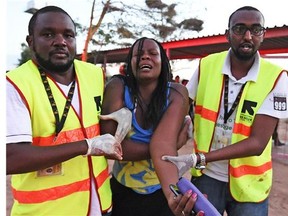 Paramedics help a student who was injured during an attack by Somalia's Al-Qaeda-linked Shebab gunmen on the Moi University campus in Garissa on April 2, 2015. At least 70 students were massacred when Somalia's Shebab Islamist group attacked a Kenyan university today, the interior minister said, the deadliest attack in the country since US embassy bombings in 1998. (Postmedia News files)