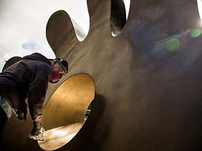 Gerard Tsutakawa, the artist responsible for the 12-foot bronze mitt outside of Safeco Field's Left Field Gate, cleans and polishes the sculpture to get it ready for the Mariners season, photographed Thursday, April 2, 2015, in Seattle, Washington. Opening Day is Monday, April 6.