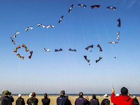 People fly their kites to form the shape of a car in the sky on the beach in Berck, northern France, on April 20, 2015, during the 29th "Rencontres Internationales de Cerfs Volants" (International Kite Meeting) which runs from April 18 to 26.