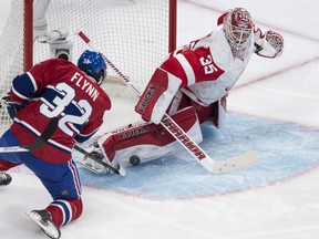 Detroit Red Wings goalie Jimmy Howard makes a save off Montreal Canadiens' Brian Flynn during first period NHL hockey action Thursday, April 9, 2015 in Montreal. THE CANADIAN PRESS/Paul Chiasson