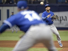 Toronto Blue Jays second baseman Devon Travis, right, throws to first baseman Justin Smoak (14) to complete a double play against Tampa Bay Rays' Steven Souza Jr. after forcing out Rene Rivera at second base during the fourth inning of a baseball game in St. Petersburg, Fla., Sunday, April 26, 2015. (AP Photo/Phelan M. Ebenhack)