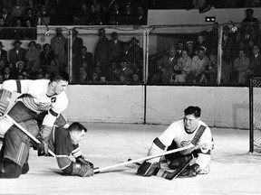 Montreal Canadiens defenceman Doug Harvey is bulldogged to the ice by Detroit Red Wings hardrock forward Ted Lindsay in front of goaltender Terry Sawchuk during a 1951 game at the Detroit Olympia. The two teams met that season in the playoffs for the fifth time in the 12 times they've now faced each other since 1937. (Detroit Times Archives)