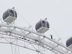 Daredevil performer Nik Wallenda walks untethered along the rim of the Orlando Eye, the city's new, 400-foot observation wheel, Wednesday, April 29, 2015, in Orlando, Fla. The walk is being done in advance of next month's public opening of the attraction. (AP Photo/John Raoux)