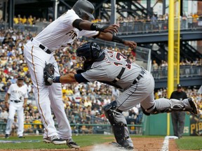 Detroit Tigers catcher Alex Avila (13) tags out Pittsburgh Pirates' Gregory Polanco (25) who was attempting to score from third on a infield grounder to Tigers first baseman Miguel Cabrera during the third inning of the Pirates home opener baseball game in Pittsburgh Monday, April 13, 2015.(AP Photo/Gene J. Puskar)