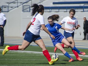 Walkerville's Jaiden Lyons, centre, battles Tira Copeland, left, and Stephanie Turner of Walkerville during the Knights' 7-0 victory at the University of Windsor Wednesday. (GABRIELLE SMITH/The Windsor Star)