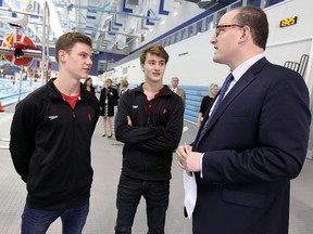 Divers Philippe Gagne, left, and Vincent Riendeau talk to Mayor Drew Dilkens during a press conference about the FINA diving competition at the Windsor International Aquatic and Training Centre in Windsor. (TYLER BROWNBRIDGE/The Windsor Star)