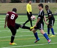 Leamington Lions Yvenel Boileau, left, strikes the ball in front of Tecumseh Vista's Stefan Trisic in senior boys high school soccer from Tecumseh Vista Academy field, Thursday April 16, 2015. (NICK BRANCACCIO/The Windsor Star)