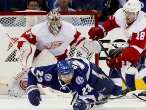 Tampa Bay Lightning right wing J.T. Brown (23) goes down as he gets  tangled up with Detroit Red Wings centre Joakim Andersson (18) in front of the net guarded by Red Wings goalie Petr Mrazek (34) during Game 1 of their NHL first-round playoff series. Brown is the son of former Minnesota Vikings running back Ted Brown.
