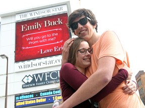 Emily Buck hugs Eric Martyn as he asks her to go to the Riverside Secondary School prom via The Windsor Star LED sign on Ouellette Avenue in Windsor, Ontario on April 14, 2015. (JASON KRYK/The Windsor Star)