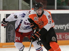 Essex 73's Eric Shaw carries the puck ahead of Mike Smith from the Port Hope Panthers during Game 3 of the Schmalz Cup Final Series at Essex Arena Sunday. (DAX MELMER/The Windsor Star)