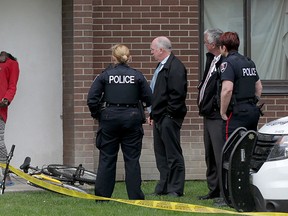 Eyewitness Mary Ojullo demonstrates to Windsor Police investigators how and where a man was stabbed at 445 Glengarry Avenue Wednesday April 22, 2015. (NICK BRANCACCIO/The Windsor Star)