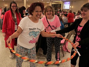 Katie Rocheleau prepares to swing into action with the hula hoop during House of Sophrosyne Signature Event Pajama Party at Fogolar Furlan Club Friday April 24, 2015. Joining the fun were Amber MacKay, left, Katie's grandmother Susan Rocheleau, behind, and Katie's Aunt Kathy Beach, right. (NICK BRANCACCIO/The Windsor Star)