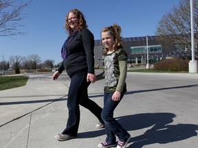 Concerned parent Heather Piccinato-Walsh walks with daughter Rowan Walsh from David Suzuki School Friday April 24, 2015. A proposed boundary change will force her children to attend Princess Elizabeth Public School even though Suzuki is a few, short blocks from her home on Esdras Place. (NICK BRANCACCIO/The Windsor Star)