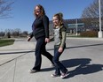 Concerned parent Heather Piccinato-Walsh walks with daughter Rowan Walsh from David Suzuki School Friday April 24, 2015. A proposed boundary change will force her children to attend Princess Elizabeth Public School even though Suzuki is a few, short blocks from her home on Esdras Place. (NICK BRANCACCIO/The Windsor Star)