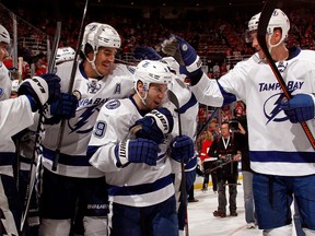 Tampa Bay’s Tyler Johnson, centre, celebrates his game winning overtime goal with Brian Boyle, left, and Andrej Sustr #62 during Game 4 of the Eastern Conference quarter-final at Joe Louis Arena Thursday.