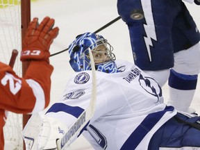 Tampa Bay Lightning goalie Ben Bishop, center, follows the puck to Detroit Red Wings left wing Tomas Tatar (21) during the third period of Game 6 of a first-round NHL Stanley Cup hockey playoff series, Monday, April 27, 2015 in Detroit. The Lightning defeated the Red Wings 5-2 to force a Game 7. (AP Photo/Carlos Osorio)